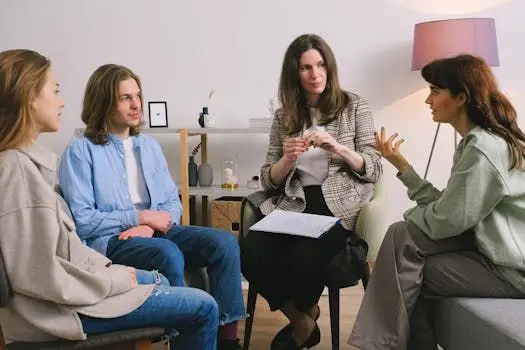 A group therapy session taking place indoors with an attentive counselor guiding the discussion.